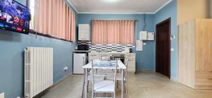 Una cocina con paredes azules y una mesa y sillas. en Guest Holiday Gambara 1 e 2, en Reggio Emilia 8 fotos más