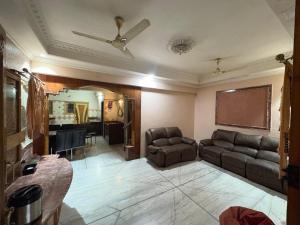 salon z kanapą i wentylatorem sufitowym w obiekcie Shree Homes w mieście Surat