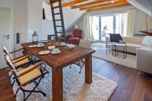 a living room with a wooden table and chairs at Ferienwohnung Loft in Strandnähe in Norden