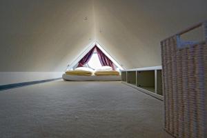 a bedroom with a bed in a room with a window at Ferienwohnung Loft in Strandnähe in Norden