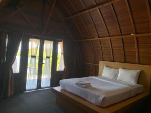 a bedroom with a large bed in a room with windows at Pandan View Mandeh Syariah in Pasarsungai-nyala