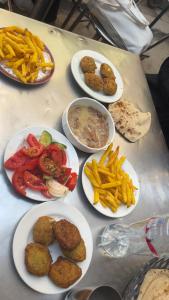 una mesa con platos de comida y patatas fritas en Tongel Nubian Studio & Guest House, en Asuán