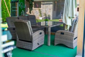 une table en verre et des chaises en osier sur la terrasse dans l'établissement Apartmaji pri Jožu, à Bohinj 22 autres photos