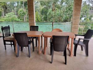 una mesa de madera y sillas en un patio en Dream Palace Kodaikanal, en Kodaikanal