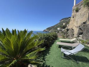 a group of chairs sitting on the grass near the ocean at Idillioravello in Ravello