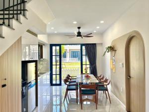 a dining room with a table and chairs and a ceiling fan at KNK villa in Bình Tú