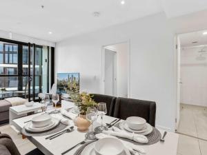 a dining room with a table with plates and wine glasses at Stylish Valley Stay in Brisbane City Hub in Brisbane