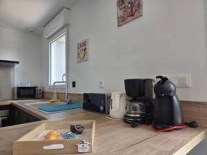 - une cuisine avec un comptoir et une cafetière dans l'établissement Maison au Coeur du Perche Arcisses Margon, à Margon 2 autres photos