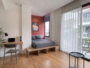 a bedroom with a bed and a desk at M Village Living 59 Thảo Điền in Ho Chi Minh City
