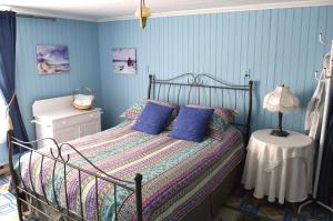 a bedroom with a bed with blue walls at La Maison entre Mer Montagnes in Cap-Chat