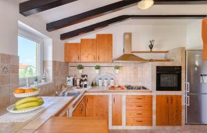 Sunny private pool apartments Seamare في ستينغان: مطبخ مع خزائن خشبية وموز على الكاونتر
