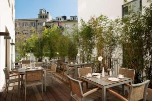 a patio with tables and chairs on a balcony at NH Frankfurt Messe in Frankfurt/Main