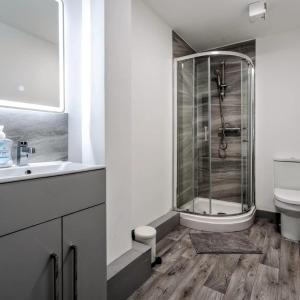 a bathroom with a shower and a sink and a toilet at Leeds 2-Bed Flat by Brookland Stays Serviced Short Lets with Free WiFi in Yeadon