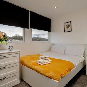 a bedroom with a bed with towels on it at Leeds 2-Bed Flat by Brookland Stays Serviced Short Lets with Free WiFi in Yeadon