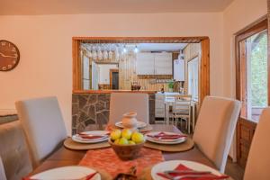 a dining room with a table with a bowl of fruit on it at Cuibul de Munte - Vilă în Breaza in Nistoreşti