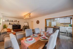 a dining room and living room with a table and chairs at Cuibul de Munte - Vilă în Breaza in Nistoreşti