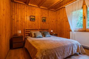 a bedroom with a large bed in a wooden room at Cuibul de Munte - Vilă în Breaza in Nistoreşti +17 photos