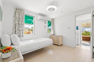 a white bedroom with a bed and a window at Boegoeroei 33E in Palm-Eagle Beach +34 photos