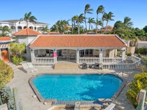 a house with a swimming pool and a gazebo at Boegoeroei 33E in Palm-Eagle Beach