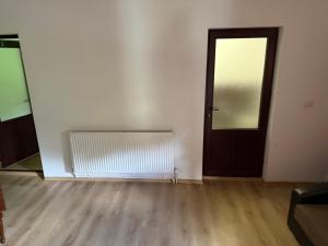 an empty room with a door and a wooden floor at La Butuci in Taşca +7 photos