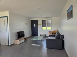 un salon avec un canapé et une table en verre dans l'établissement Maison au Coeur du Perche Arcisses Margon, à Margon