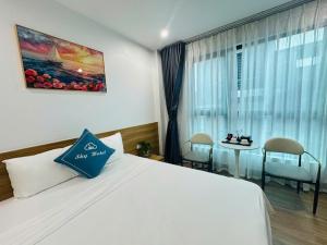 ニンビンにあるSky Hotelのベッドとテーブルと椅子のあるホテルの部屋
