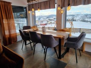 a dining room with a table and chairs and a large window at Sielsko i Diabelsko in Jaworzynka