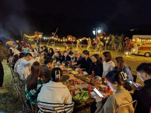 Hữu LũngにあるMichi Camp Hữu Liênの食べ物を囲んでテーブルの周りに座っている人々のグループ +46枚の写真