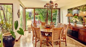 a dining room with a wooden table and chairs at Spacieuse villa avec piscine privée à Saint-Gilles les Bains 300 m² in Grand Fond