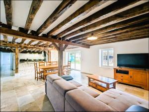 a living room with a couch and a flat screen tv at Janedala gite 8 pers Levroux in Levroux
