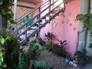 una escalera en una casa rosa con plantas en Pousada Sol e Mar en Parajuru