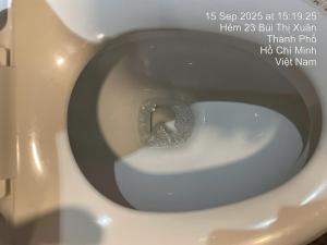 a close up of a white toilet bowl with a label at Anna Lim Hotel 7 in Ho Chi Minh City