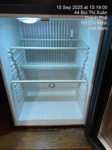 a refrigerator with empty shelves in a room at Anna Lim Hotel 7 in Ho Chi Minh City