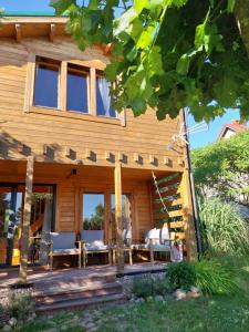 a wooden house with a porch and a patio at Dom Pod Sosnami in Lidzbark