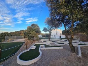 a park with a labyrinth of stones and trees at The White House in Cazalegas
