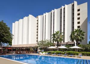 a large white building with a swimming pool at Novotel Dakar in Dakar