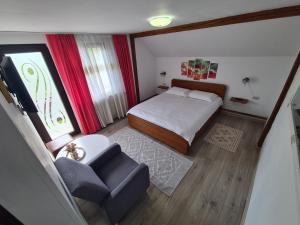 a small bedroom with a bed and a chair at Casa Claudia in Slănic-Moldova