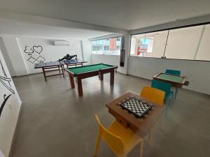 una habitación con mesas de ping pong y sillas. en Paraíso em Tamandaré - Maui Beach, en Tamandaré