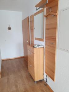 Un vestidor con espejo y una cómoda de madera. en Baltique Fewo 3, en Glowe