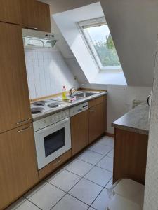 Una cocina con estufa, fregadero y ventana. en Baltique Fewo 3, en Glowe