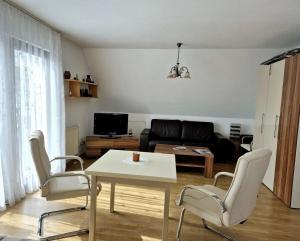 Una sala de estar con una mesa y sillas y un sofá. en Baltique Fewo 3, en Glowe