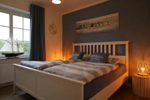 a bedroom with a large bed and a window at Ostfresenstuv in Neßmersiel