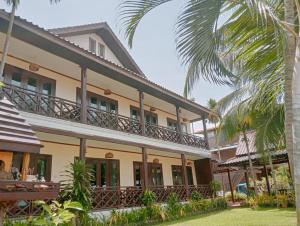 an exterior view of a house with a palm tree at Sengahloune Villa in Ban Khon