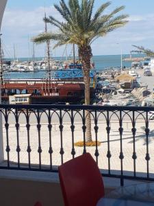 a view of a harbor with a palm tree and a train at Marina 105-102-104-103 in Houmt Souk +2 photos