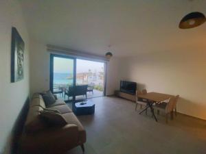 una sala de estar con un sofá y una mesa en Wake Up by the Sea Oceanfront Garden Retreat with Pool, en Küçükerenköy