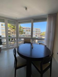 Una mesa y sillas en una habitación con una ventana grande. en Casa Nana, en L'Alfas del Pi