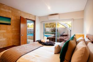 Un dormitorio con una cama grande frente a una ventana. en Eagle Bay Beach Retreat - Steps from the Sands, en Dunsborough 25 fotos más