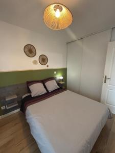 ベルク・シュル・メールにあるAppartement récent à deux minutes de la plageのベッドルーム1室(大型ベッド1台、壁に2つの時計付)