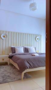 a bedroom with a bed with a white headboard at Cosy&chill&piscine&3min à la plage in Bouznika