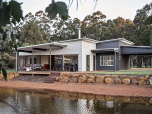 a house on the side of a body of water at Lang Chalet - Vineyard Bliss on the Waterfront in Wilyabrup